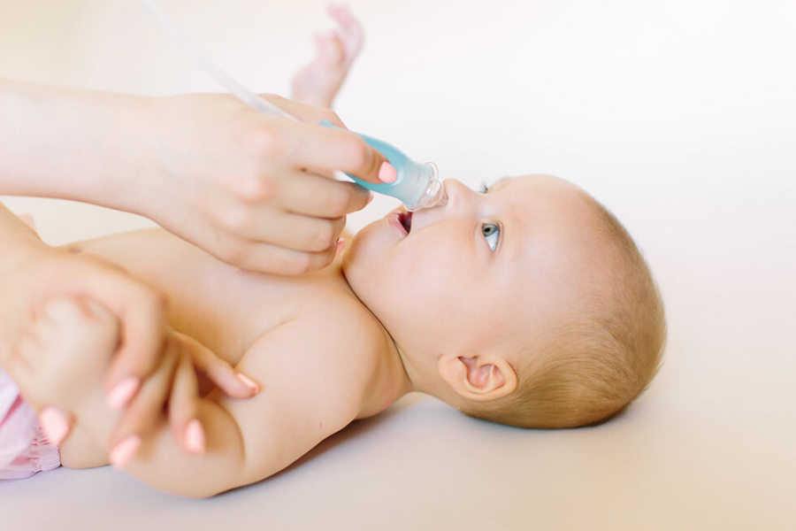Mamma usa aspiratore nasale sul suo bebe